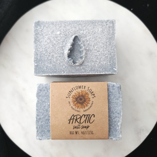 Two bars of Arctic Soaps on a marble surface with a black background
