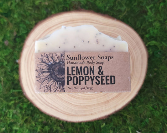 Handmade body soap bar with 'Sunflower Soaps' label on a green moss background